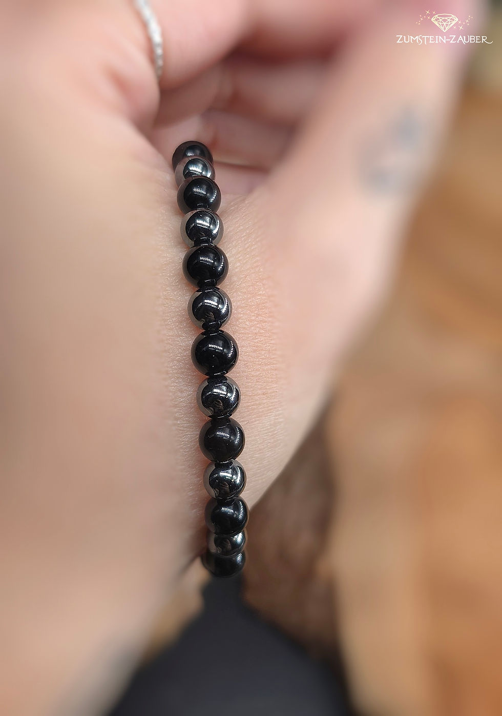 Miniaturbild: Armband auf Elast aus Hämatit und Obsidian, Beispiel auf der Hand