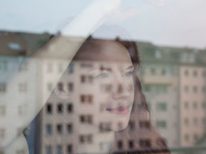 Mujer mirando por una ventana, sensación de pausa y búsqueda de claridad para empezar.