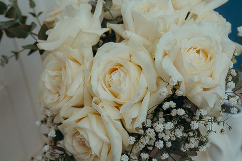 Hochzeit im Soho House Berlin – Hochzeitsfotograf Michael Oertel. Luxuriöser Brautstrauß mit cremeweißen Rosen und zartem Schleierkraut.