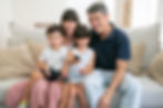 happy-excited-family-couple-and-two-kids-watching-tv-together-sitting-on-couch-in-living-r