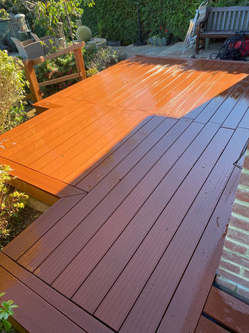 a wooden deck with a brick wall in the background