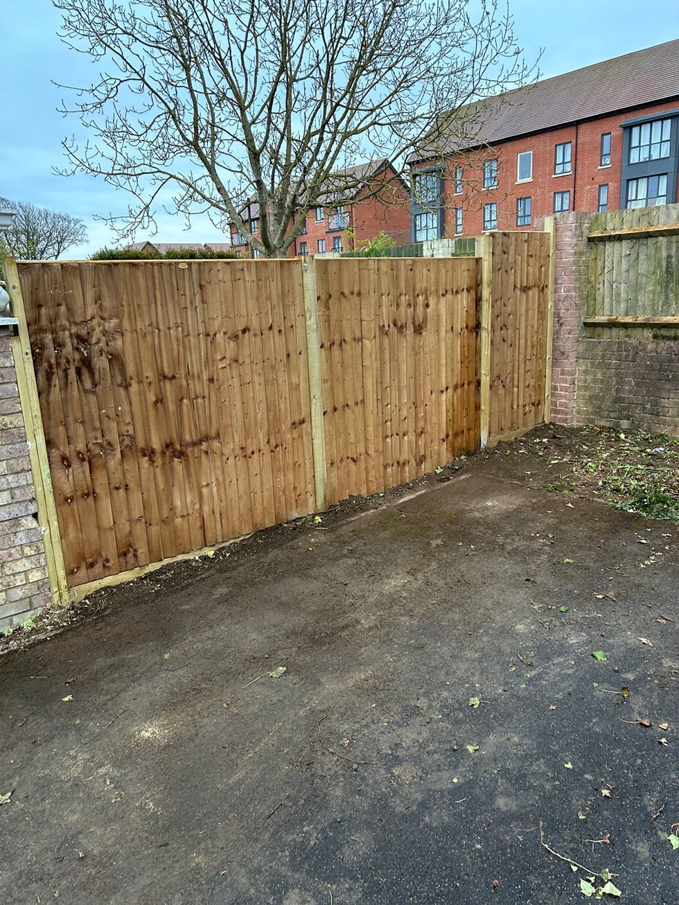 a wooden fence with a brick wall in the background