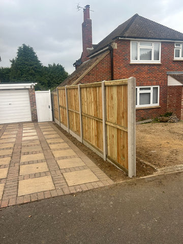 a wooden fence is in front of a brick house