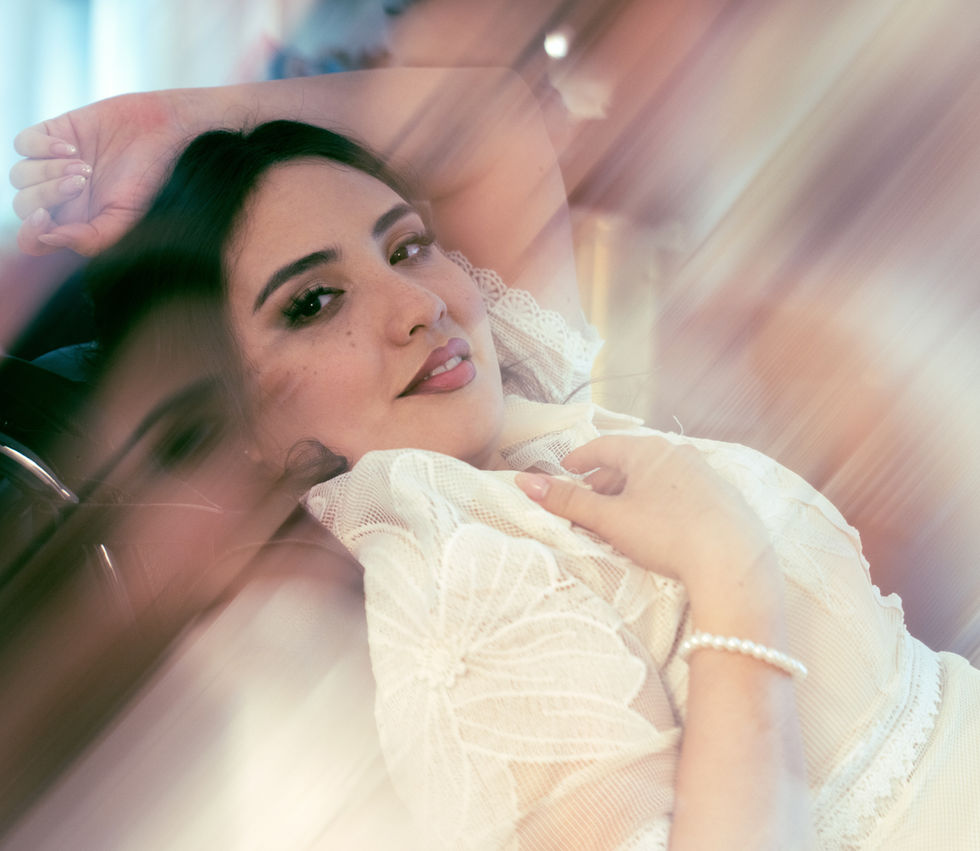 Woman lying down, wearing white, with a serene expression.