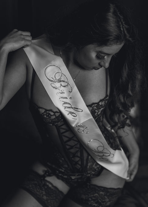 Black and white photo of woman with "Bride to Be" sash.