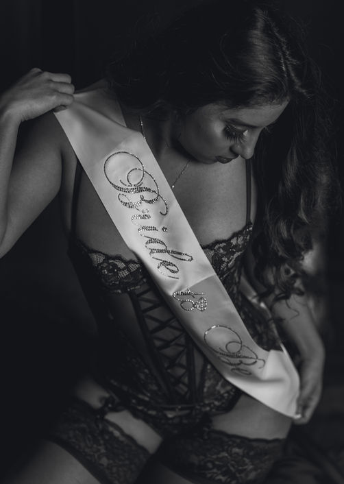 Black and white photo of woman with "Bride to Be" sash.