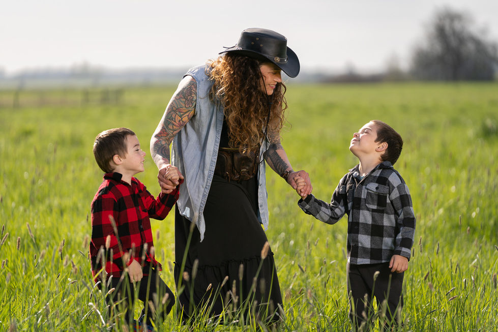 Person with two children in a grassy field.