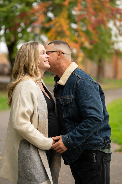 Couple embracing outdoors, smiling affectionately.