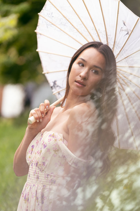 Woman holding parasol in outdoor setting.