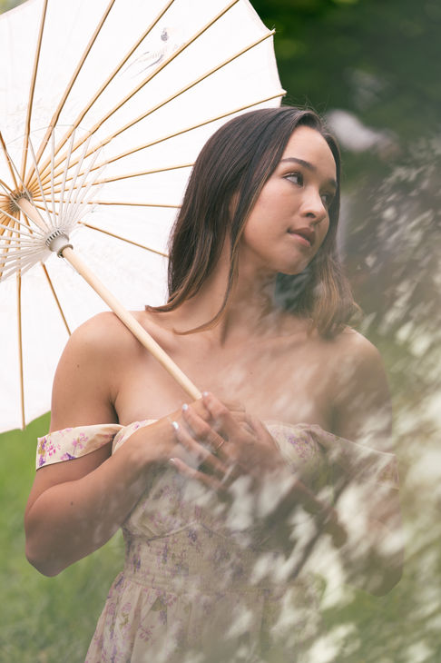 Woman holding parasol in outdoor setting.