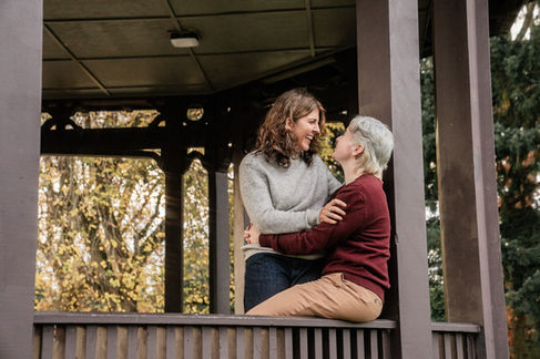 Two people embracing on a wooden porch.