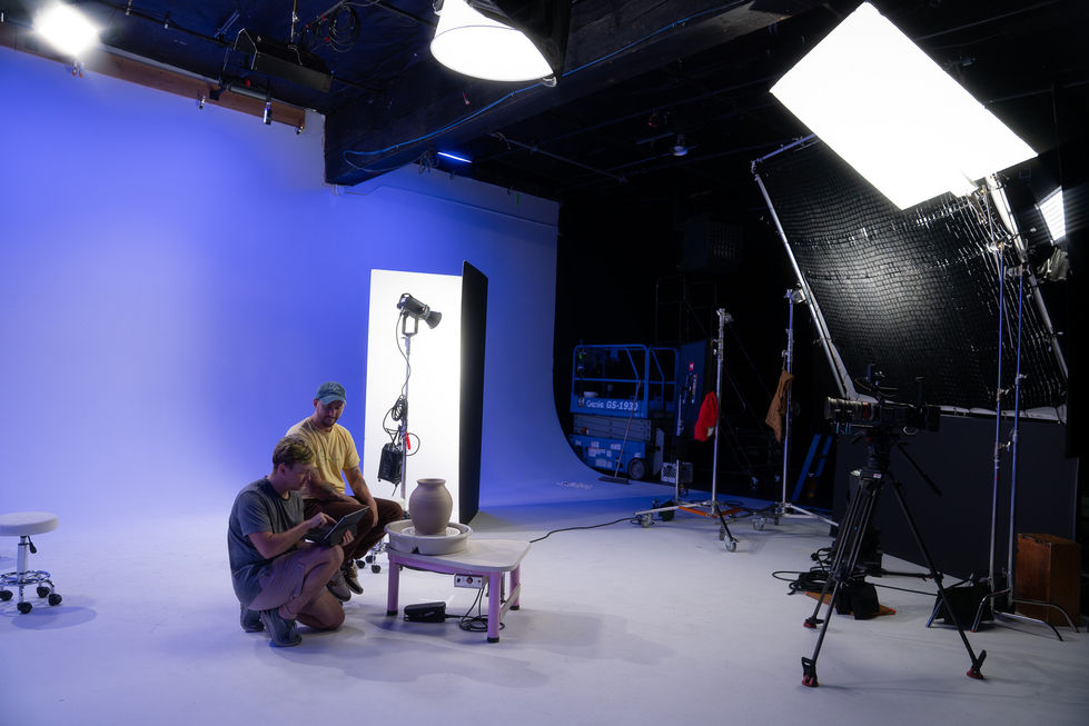Studio setup with photographers and lighting equipment.