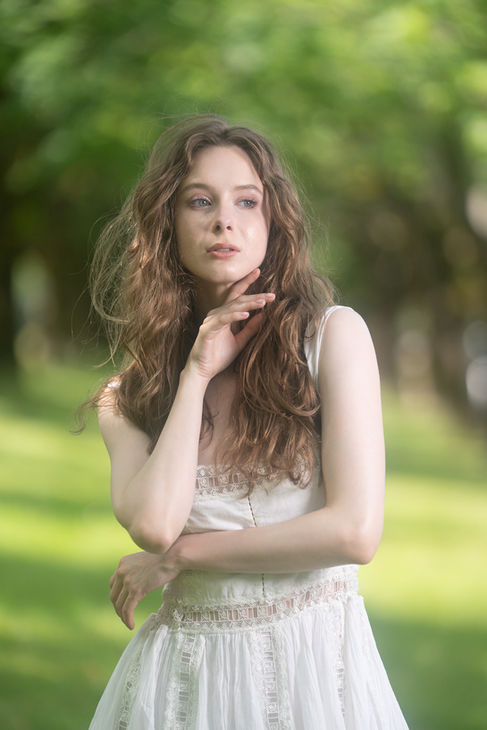 Woman posing outdoors with long, wavy hair.
