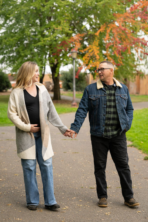 Couple holding hands, walking in a park.