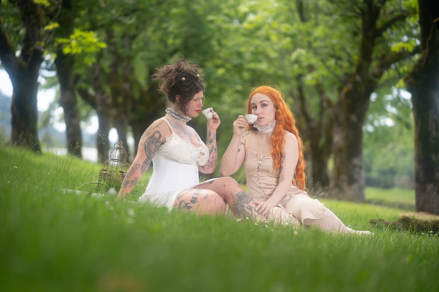 Two people having tea in a grassy park.