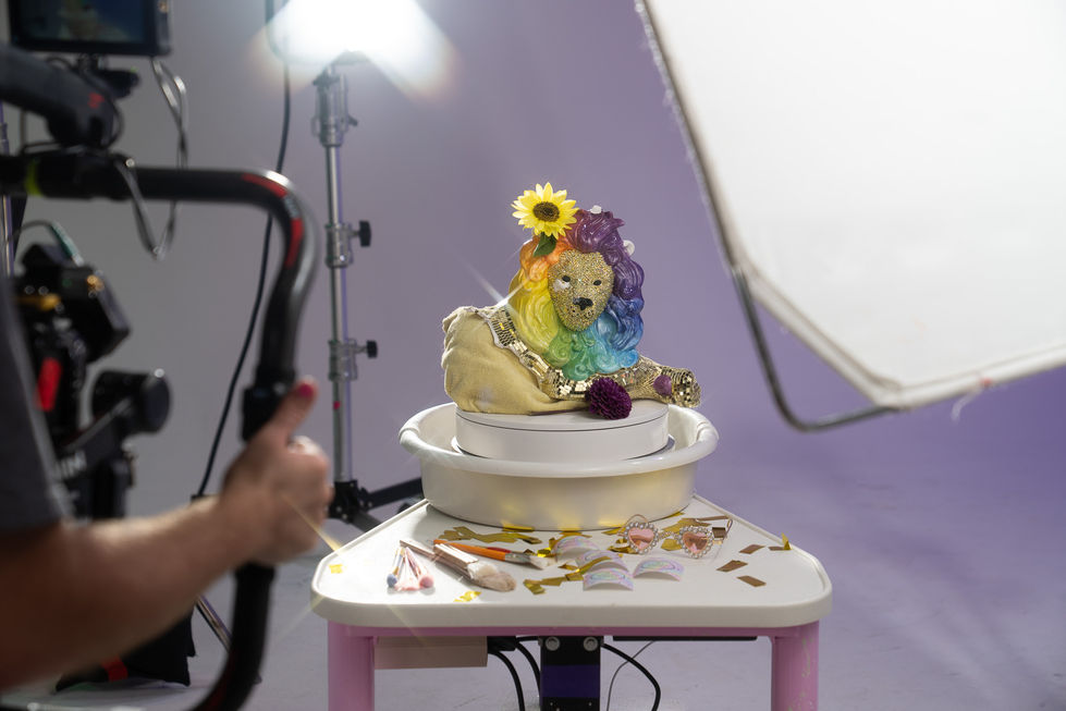 Colorful sculpture with rainbow hair and sunflower decoration.