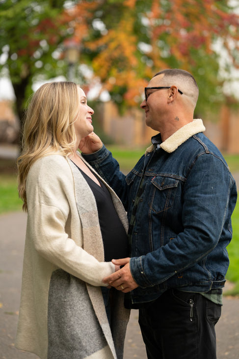 Couple smiling and holding hands outdoors.