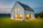 Contemporary luxury home with lit windows and manicured lawn in Solon Ohio.