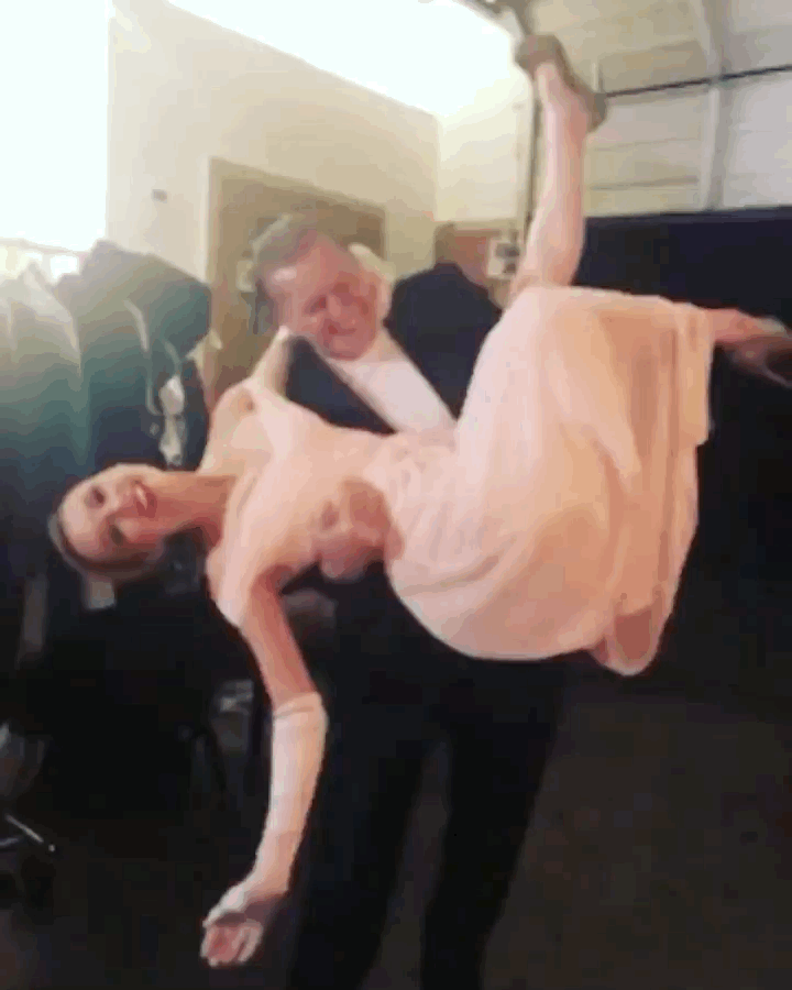 man holding dipping woman pink gown