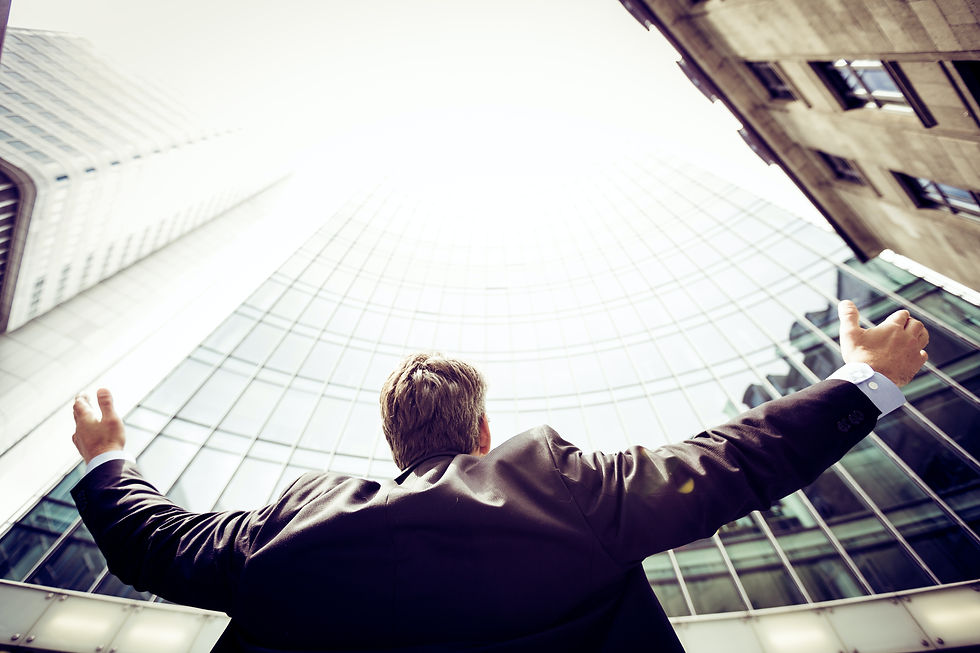 Man looking up to sky surrounded by buildings, indicating possibility