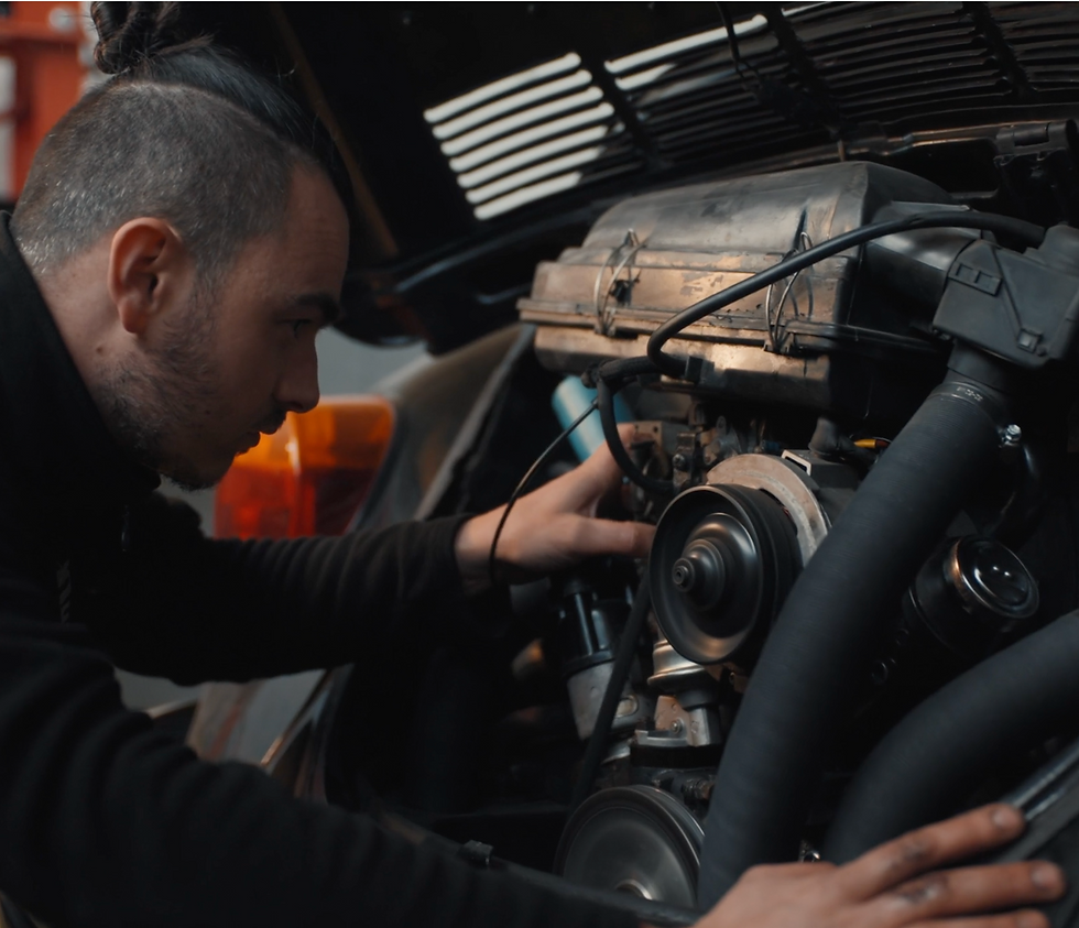 Mécanicien inspectant le moteur d'une voiture ancienne.
