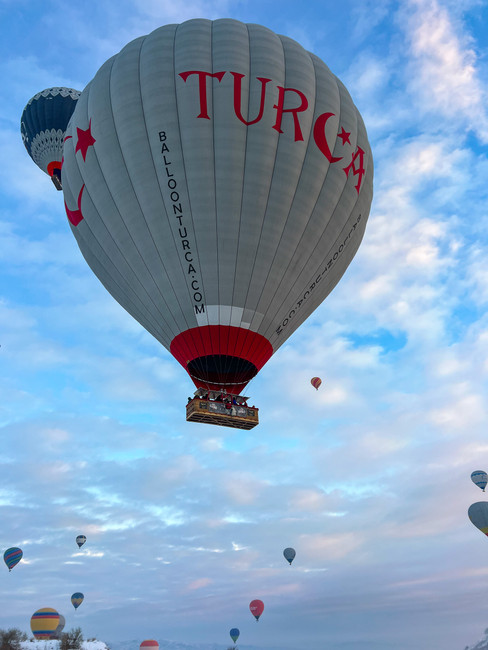 Hot air balloons flying in Cappadocia at sunrise from the Love Valley viewpoint