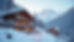 Close-up view of a cozy mountain lodge exterior with snow-covered Swiss Alps in the background