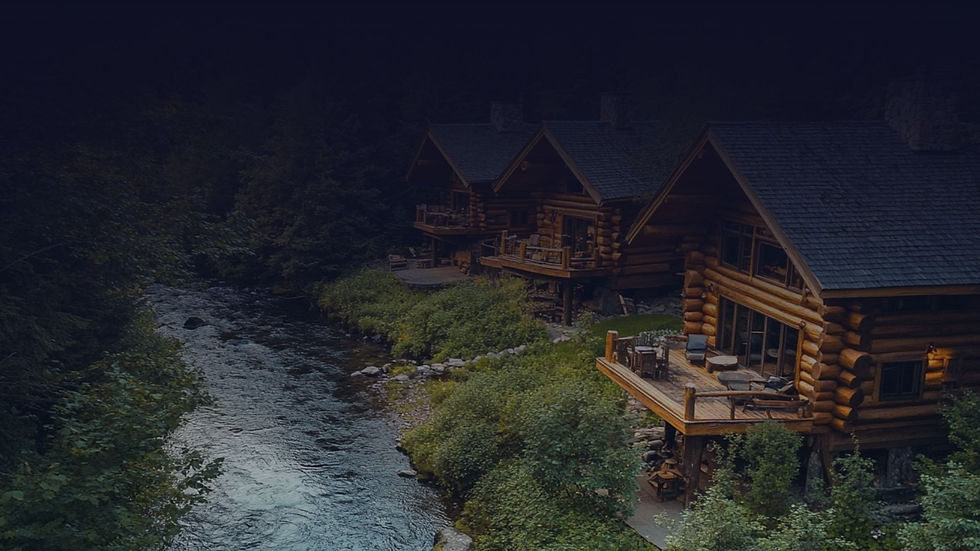 Row of log cabins with decks along a river