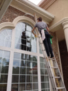 Person on a ladder cleaning windows.