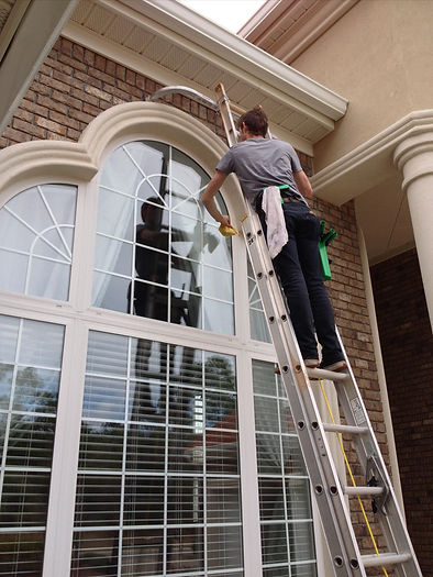 Person on a ladder cleaning windows.