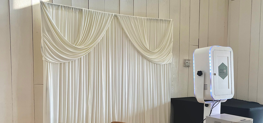 draped backdrop and photo booth at wedding 