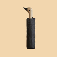 Compact black umbrella with a carved wooden duck-head handle.