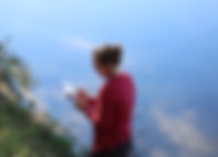 Image of staff member doing a survey of a body of water while holding a clipboard