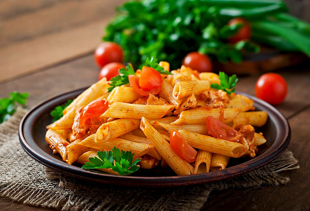 macarrao-penne-em-molho-de-tomate-com-frango-e-tomate-em-uma-mesa-de-madeira.jpg