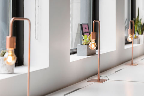 Modern interior setting with a sleek copper lamp on a windowsill, promoting ArtEssence bespoke wallpaper art services for interior designers.