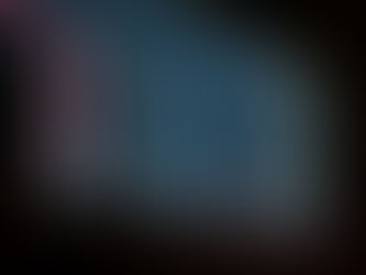 A long exposure of multicolored lights moving down a black background.
