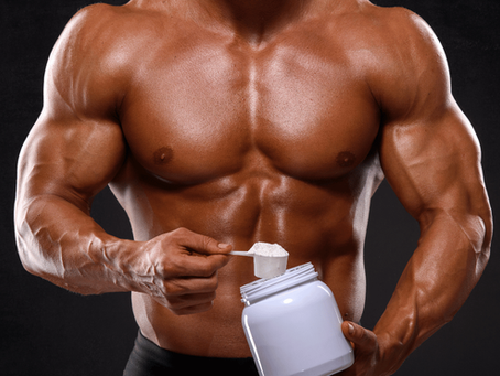 A muscular man scoops powdered colostrum from a container, ready to boost his fitness regimen.