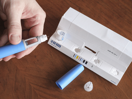 A man carefully prepares a GLP-1 injection, organizing the components on a table as he readies himself for the shot.