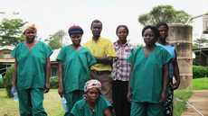 This image was taken on the grounds of Kagadi Hospital, in the Kibaale District of Uganda, during that nation’s July - August 2012, Ebola outbreak. Dressed in their green-colored scrubs, and white rubber boots, these were members of the hospital staff, who had stopped to pose for this quick portrait. Note the somber expressions each staff member displayed, reflecting the seriousness of their plight. According to the World Health Organization (WHO), it was inside the Kibaale District that the 2012, Ugandan Ebola outbreak began.