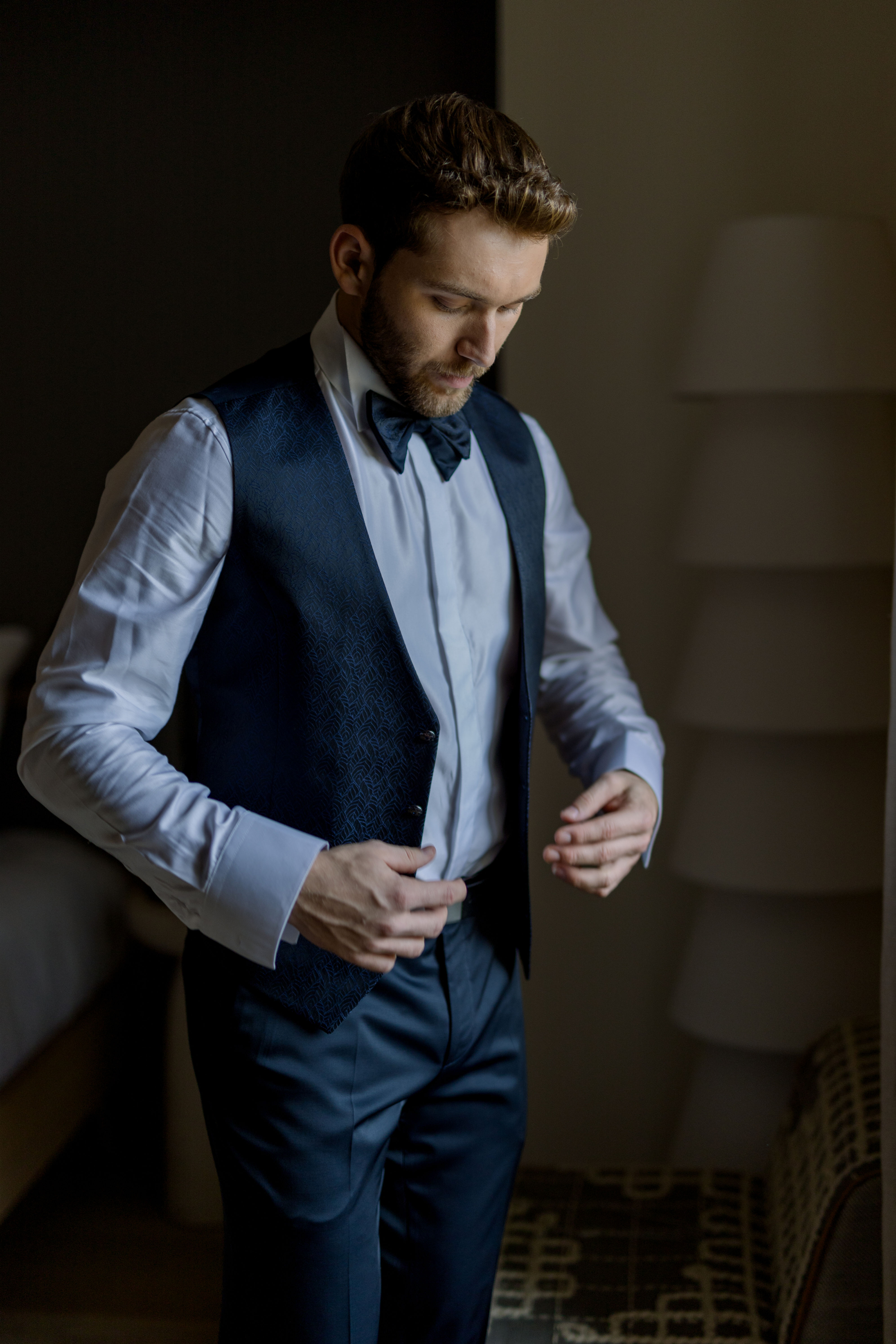 Homme en train de boutonner son costume lors de la prise de mesure finale à Montpellier, préparatif de mariage
