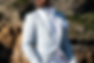 Homme en costume en jacquard blanc luxueux dans les rochers a la mer à Montpellier.