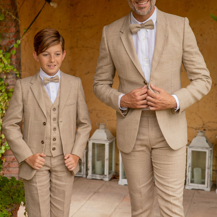 Père et fils en costumes trois-pièces en lin beige, nœud papillon et bretelles vintage — Hosana Showroom Montpellier