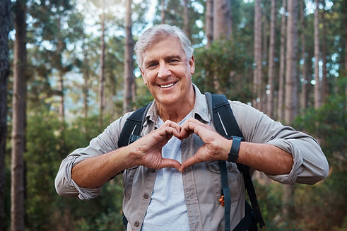 Portrait, heart and senior man in forest hiking, fitness and health support, self care han