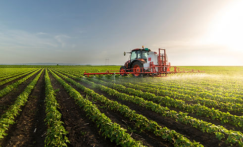 Tractor spraying pesticides on soy field with sprayer at spring.jpg