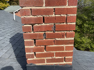 Cracked, deteriorating brick chimney before repair in the New River Valley