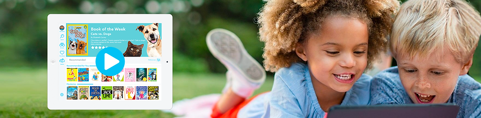 A young girl and boy laying on grass smiling and reading