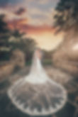 Wedding photography of bride and groom at beautiful outdoor venue, Secret Gardens Miami, with couple standing on stone bridge at sunset.