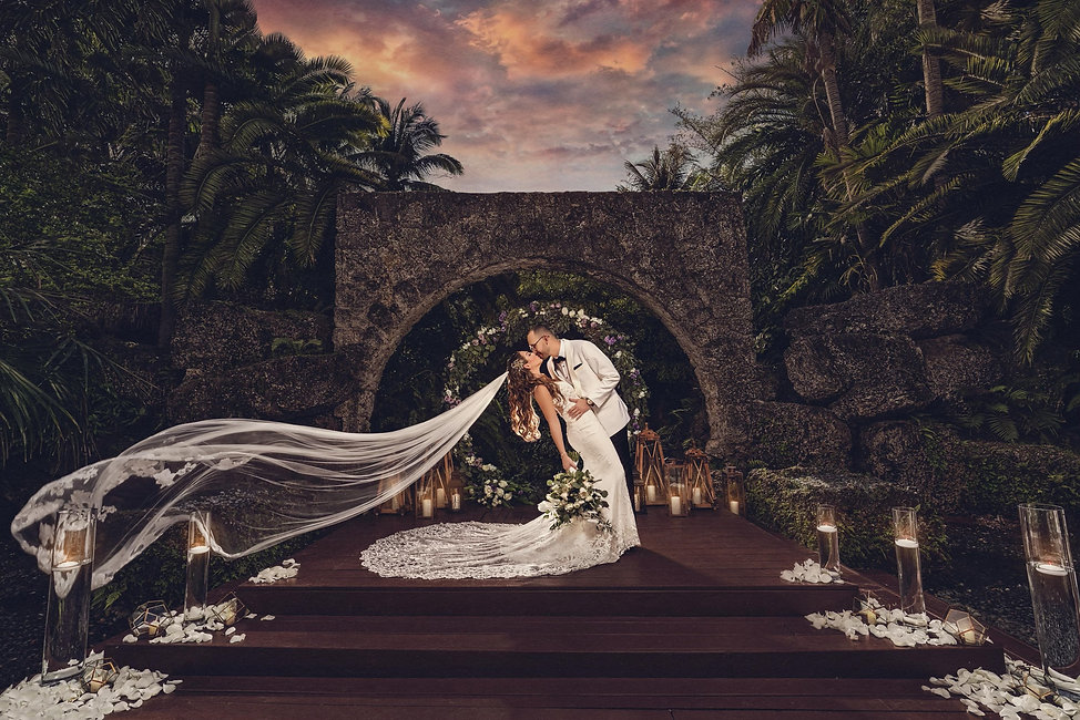 Wedding photography of bride and groom at beautiful outdoor venue, Secret Gardens Miami, with stone and ceremony set up.