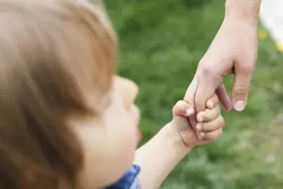 Adult holding a child's hand