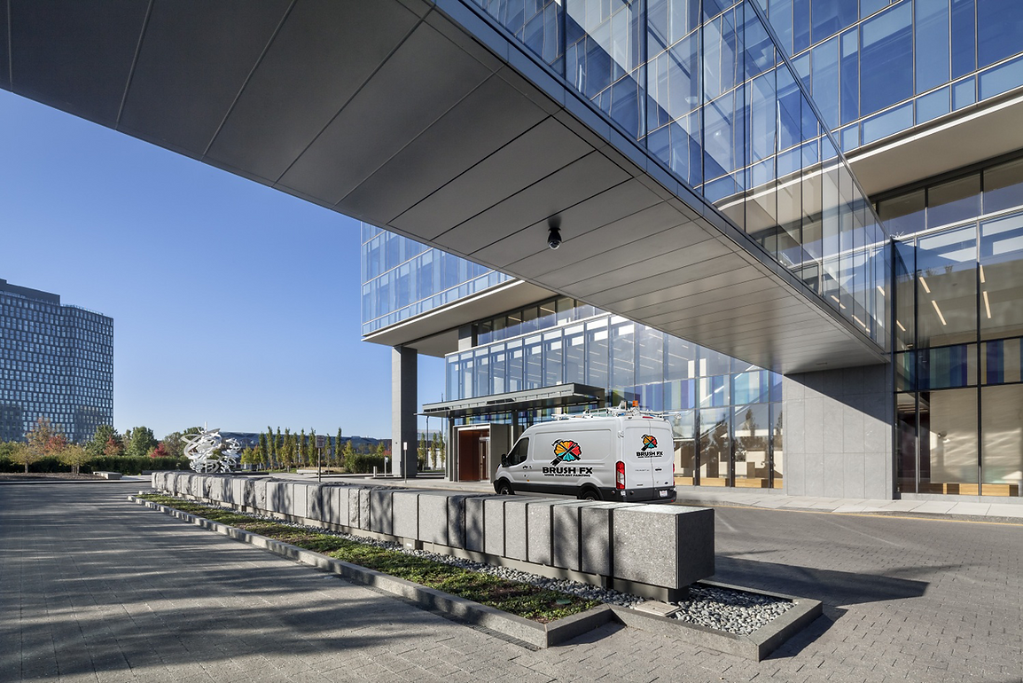 Brush FX service van parked outside a modern commercial office building.